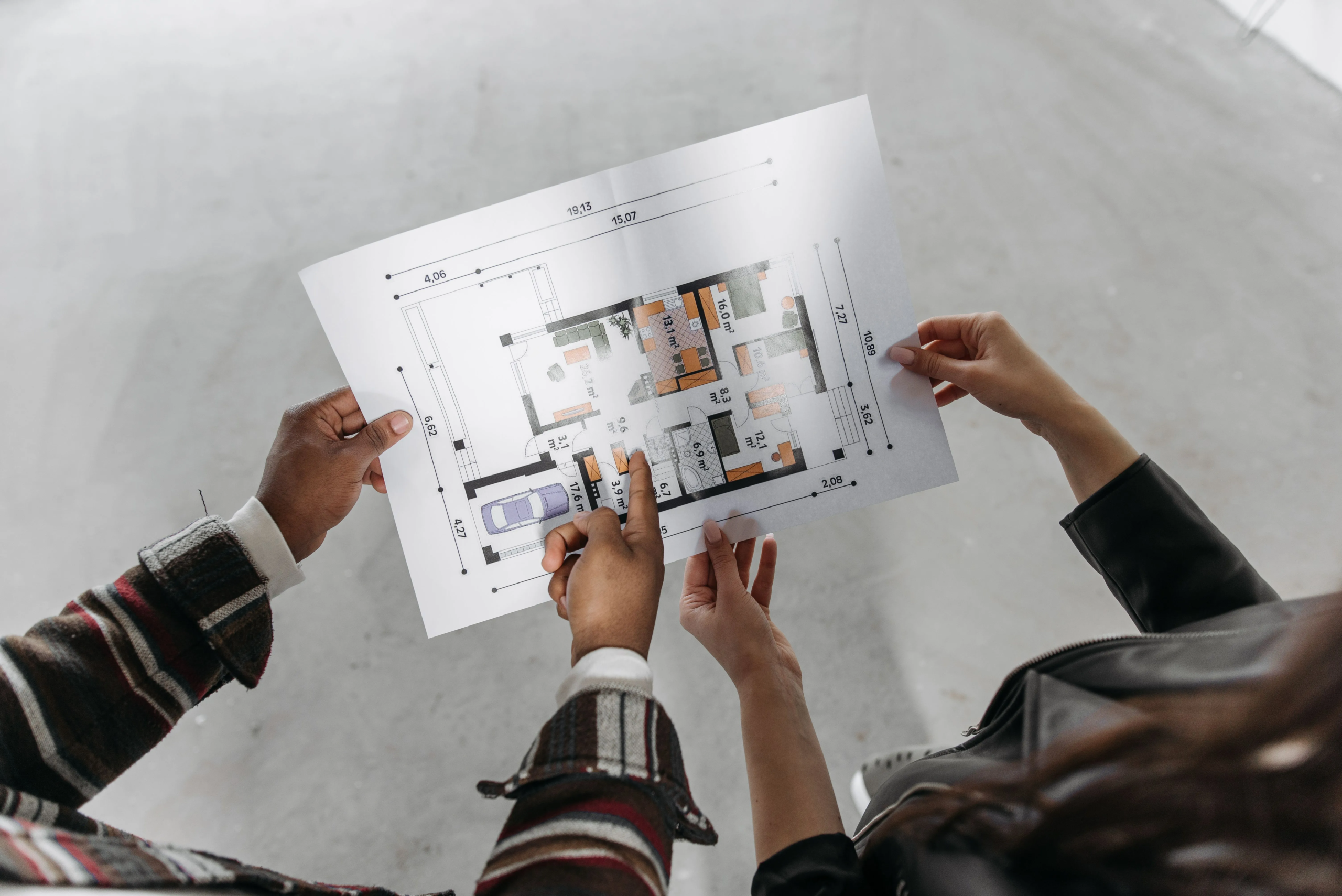 People reviewing a floor plan during the house sale process.