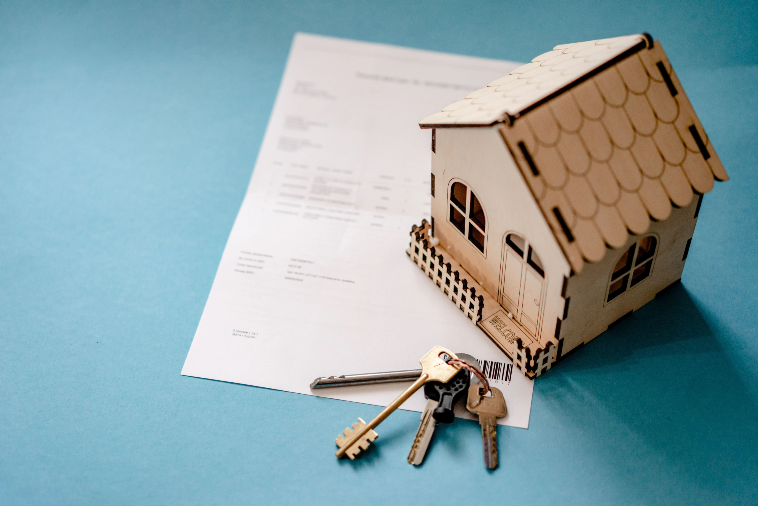 House model, keys and paperwork showing the process of selling a house.