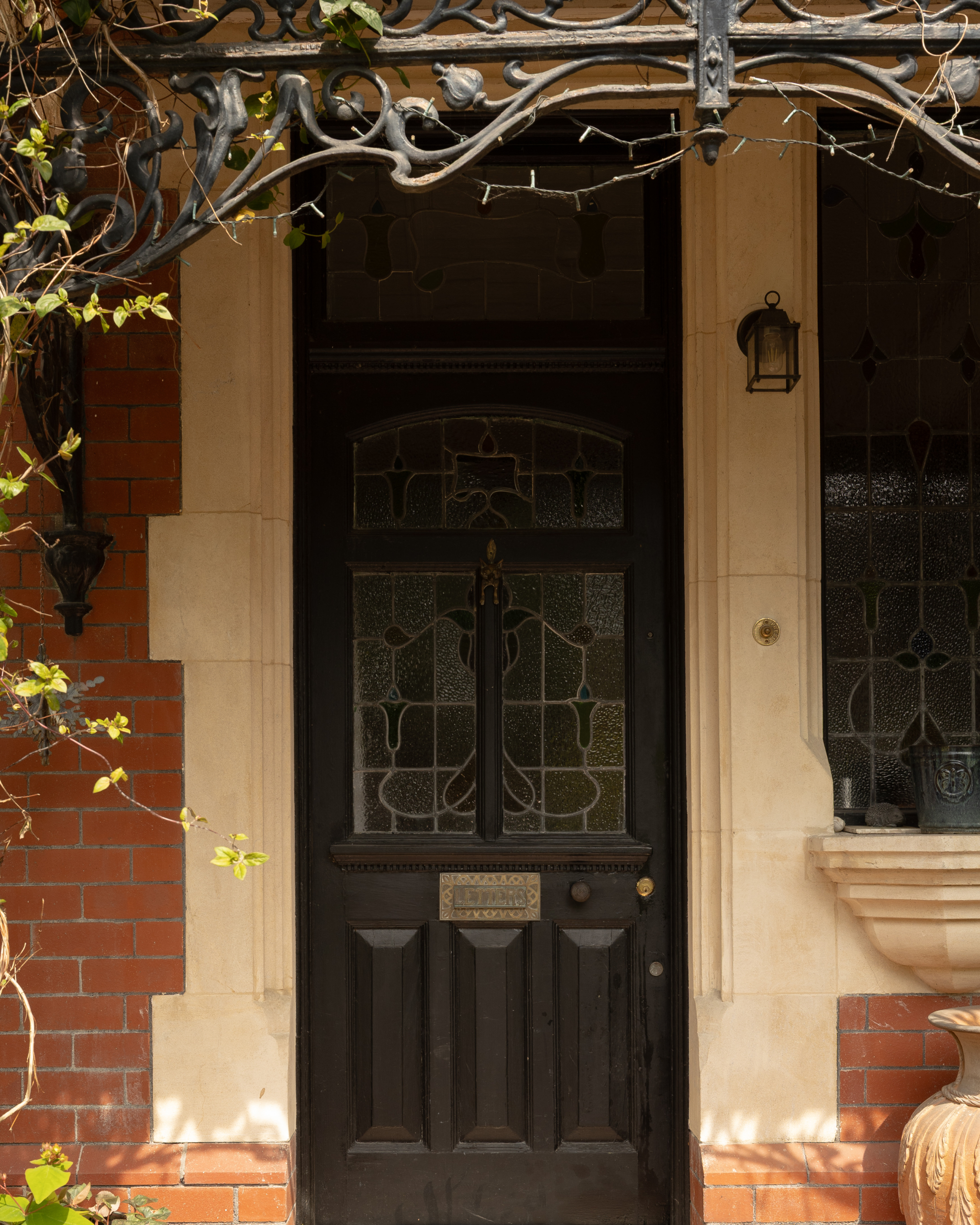 Stained glass front door and lantern in the covered porch of a Victorian villa in Roath